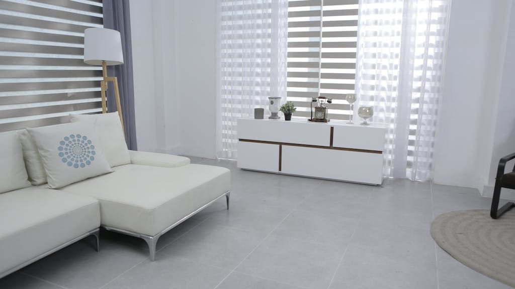 Bright and spacious living room featuring modern minimalist decor, a white sofa, and sleek furniture.